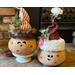 Here are two Christmas Elves decorating a fireplace hearth. They each have happy faces carved into their gourd shells with custom Elf hats